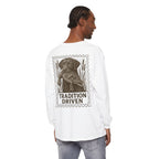 Person wearing a white long-sleeve shirt with a graphic of a dog and 'Tradition Driven' text on the back.