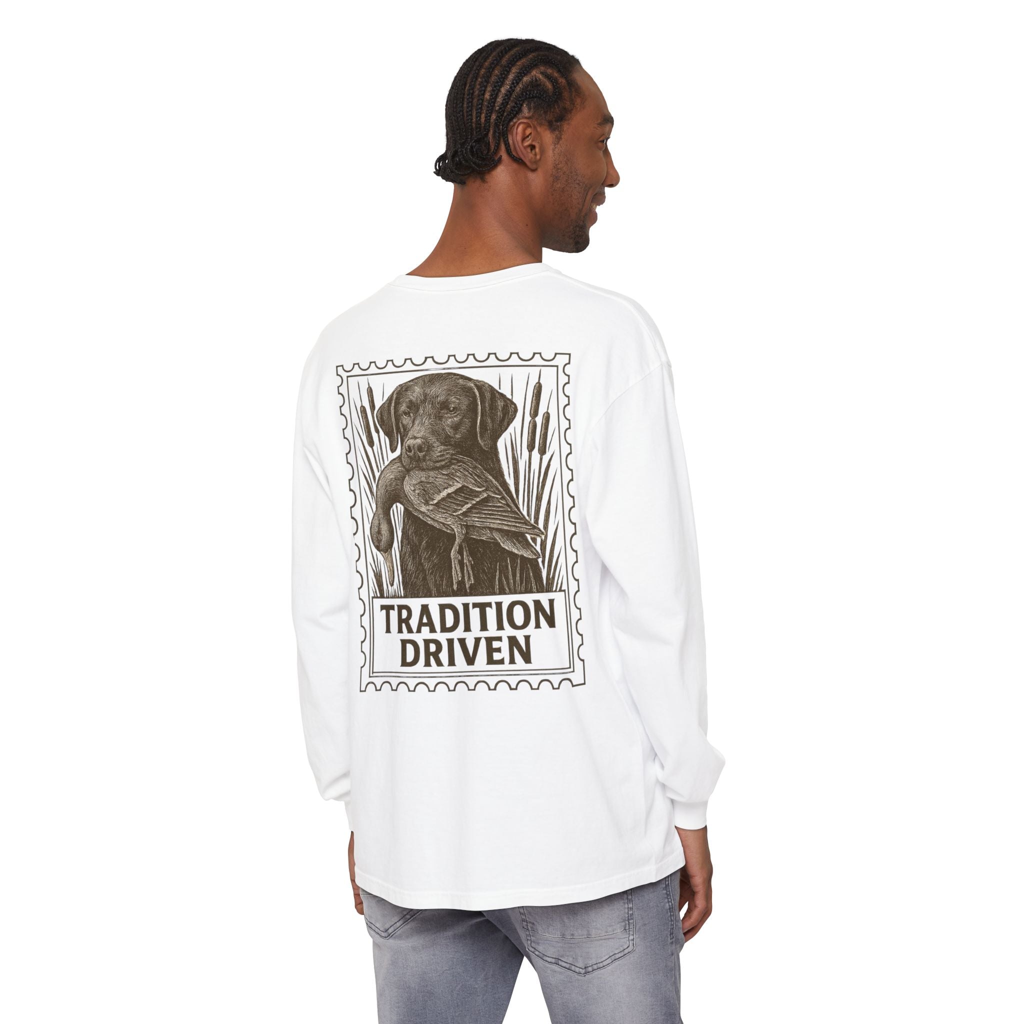 Person wearing a white long-sleeve shirt with a graphic of a dog and 'Tradition Driven' text on the back.